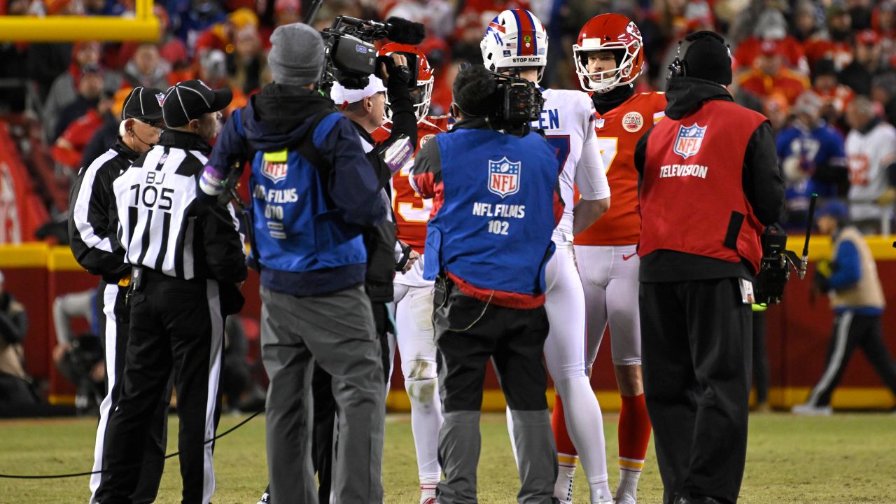 Chiefs and Bills players meet at midfield for the coin toss to determine who will get the ball to start the overtime period in their NFL Divisional Playoff game.