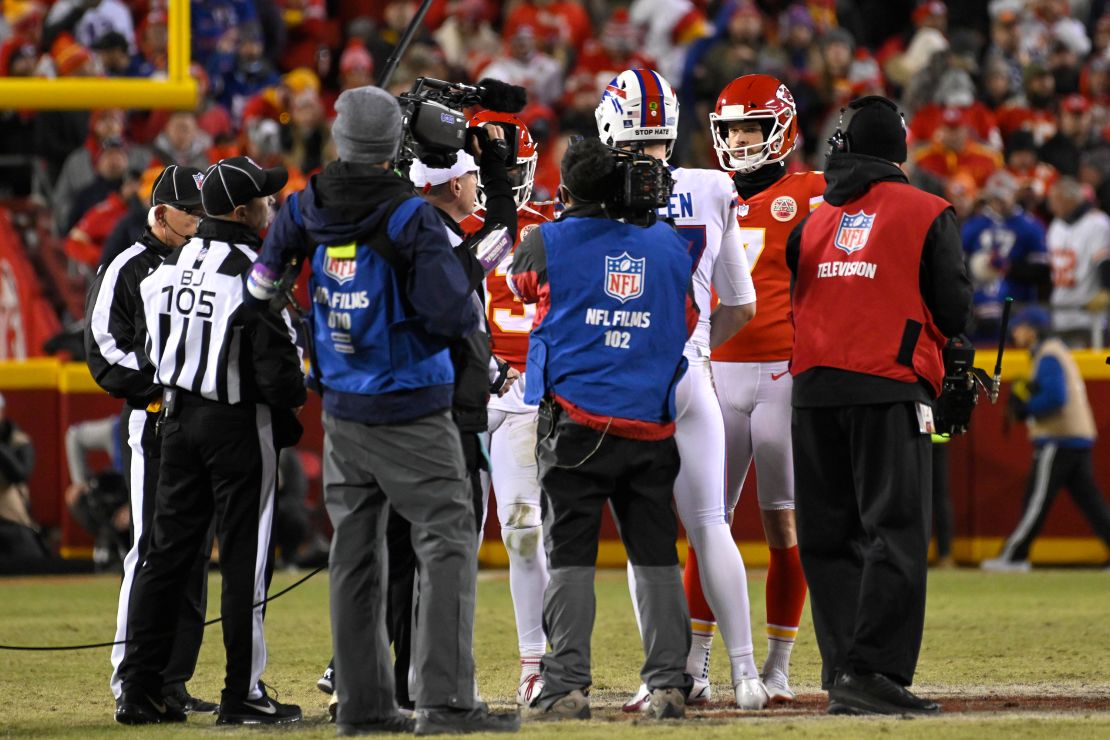 Chiefs and Bills players meet at midfield for the coin toss to determine who will get the ball to start the overtime period in their NFL Divisional Playoff game.
