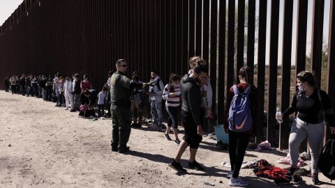 A US Customs and Border Protection officer directs migrants seeking asylum into vans before transferring them to temporary shelters in Yuma, Arizona, in February. 