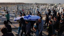 Mourners carry the body of 67-year-old Menahem Yehezkel, who was killed the previous day in a knife attack by a convicted Islamic State group sympathiser, during his funeral in the southern Israeli city of Beersheba  on March 23, 2022. Israel prepared to hold funerals for four people killed in the attack, that was one of the country's deadliest in recent years. The assailant, who Israeli media identified as Mohammed Abu al-Kiyan, is an Arab Israeli who had previously tried to join IS. He was shot dead by armed bystanders, police said.