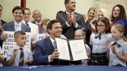Florida Gov. Ron DeSantis displaying the signed Parental Rights in Education, aka the Don't Say Gay bill, flanked by elementary school students during a news conference on March 28, 2022.