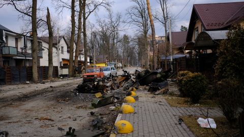 A destroyed Russian armored personnel carrier blocks part of a road in Irpin.