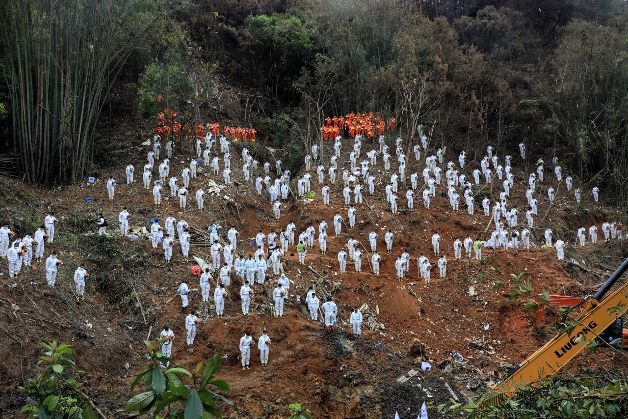 Rescue workers stand for a moment of silence on Sunday, March 27, as they pay tribute to the 132 people who died in a <a href="https://www.cnn.com/2022/03/22/china/china-eastern-airlines-plane-crash-tuesday-intl-hnk/index.html" target="_blank">plane crash</a> in southern China's Guangxi region on March 21.