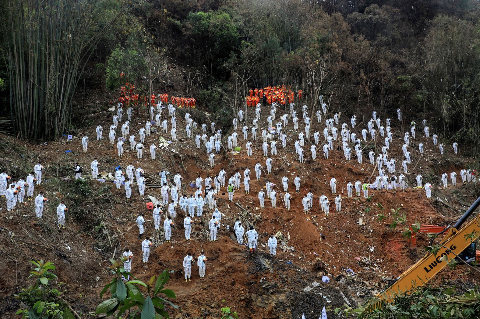 Rescue workers stand for a moment of silence on Sunday, March 27, as they pay tribute to the 132 people who died in a <a href="index.php?page=&url=https%3A%2F%2Fwww.cnn.com%2F2022%2F03%2F22%2Fchina%2Fchina-eastern-airlines-plane-crash-tuesday-intl-hnk%2Findex.html" target="_blank">plane crash</a> in southern China's Guangxi region on March 21. 
