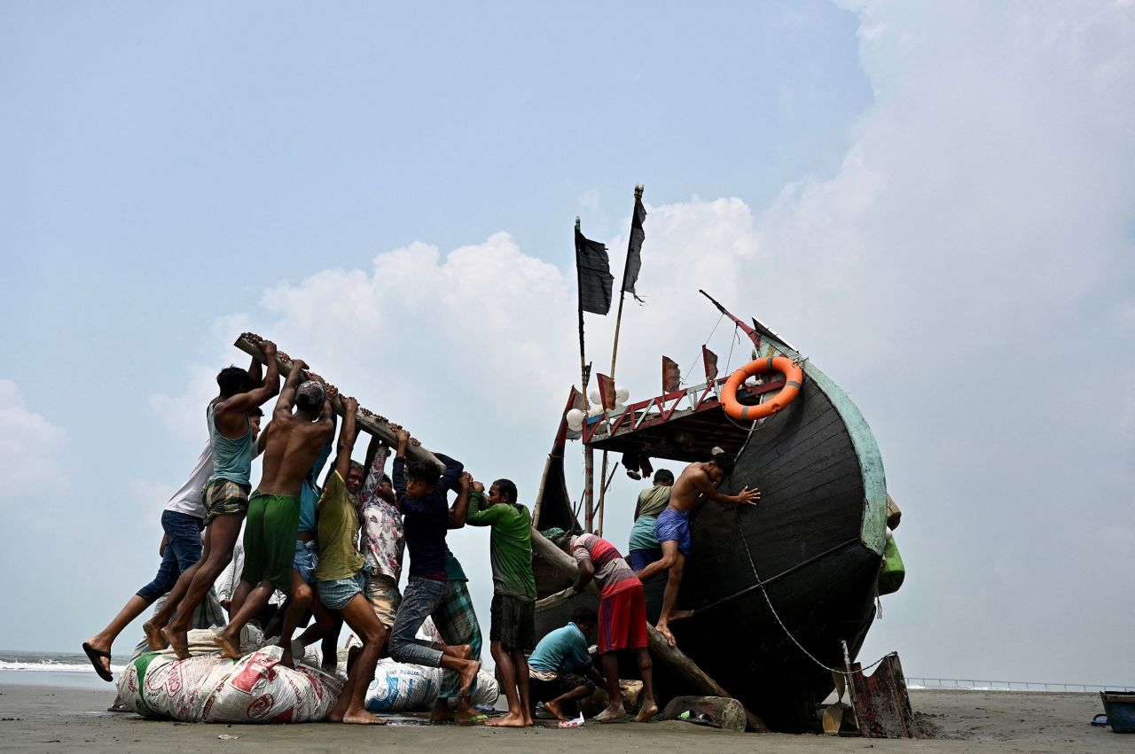 Fishermen try to lift a stranded boat in Teknaf, Bangladesh, on Monday, March 28.