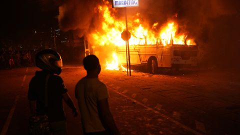 Šrilankieši protesta akcijas laikā pie prezidenta mājām Kolombo 1.aprīlī vēro degošu autobusu.