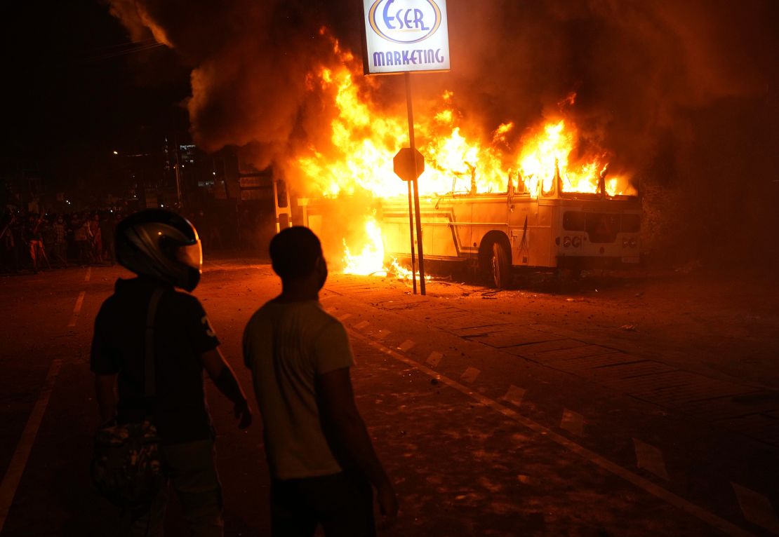 Sri Lankans watch a burning bus during a protest outside the President's home in Colombo on April 1.