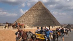 People ride on carriages at the Giza complex, on the southwestern outskirts of the Egyptian capital Cairo.