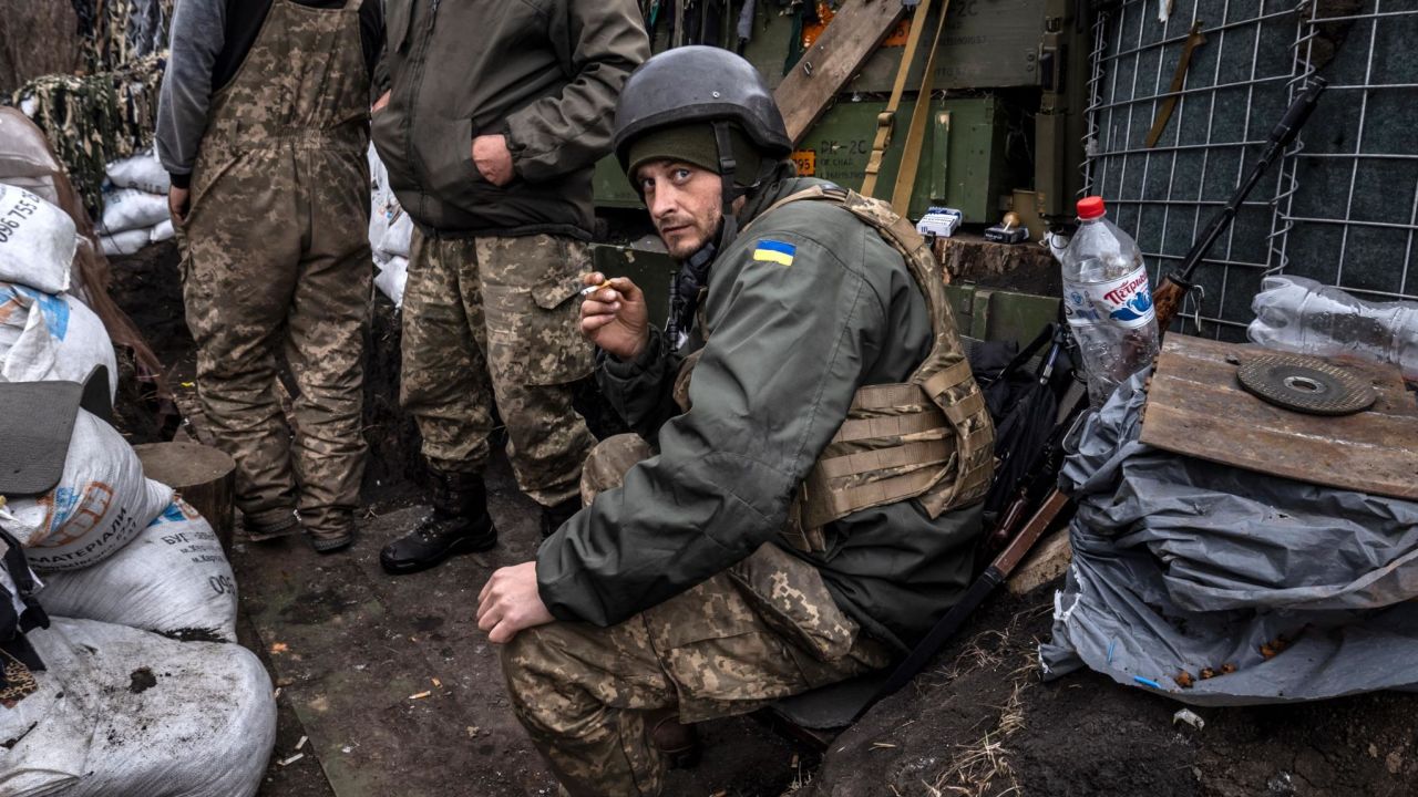 A Ukrainian serviceman smokes a cigarette in a trench at the front line east of Kharkiv on March 31, 2022.