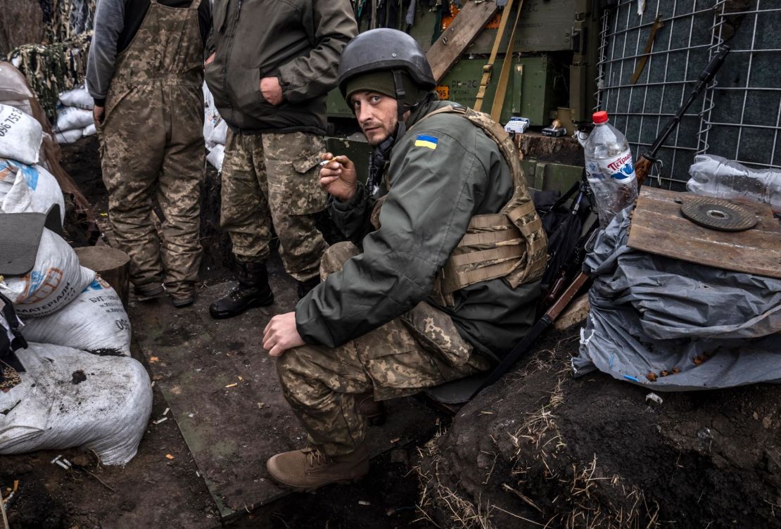 A Ukrainian serviceman smokes a cigarette in a trench at the front line east of Kharkiv on March 31, 2022.