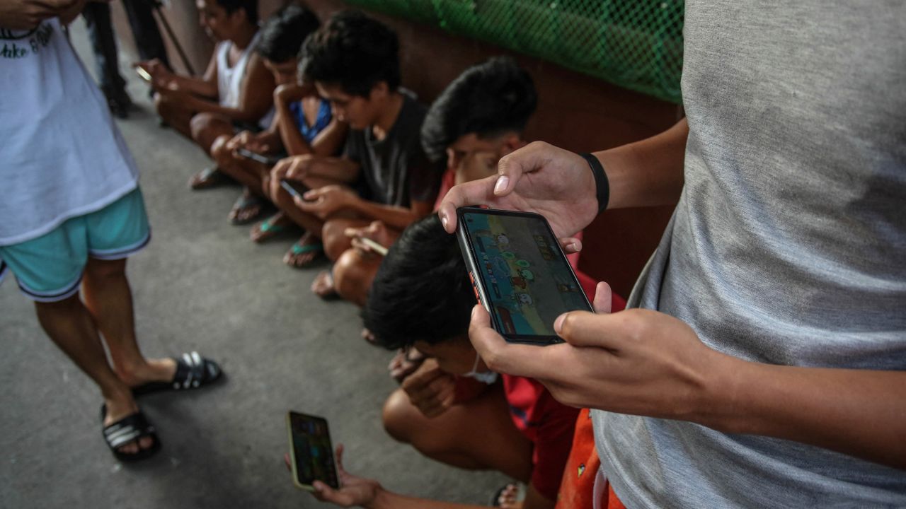 People using their mobile phones to play Axie Infinity in Malabon, Philippines.