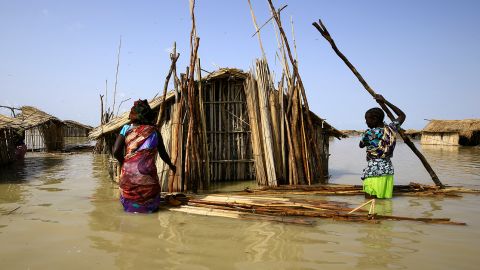 South Sudanese refugees try to repair their hut during the country's floods in 2021.