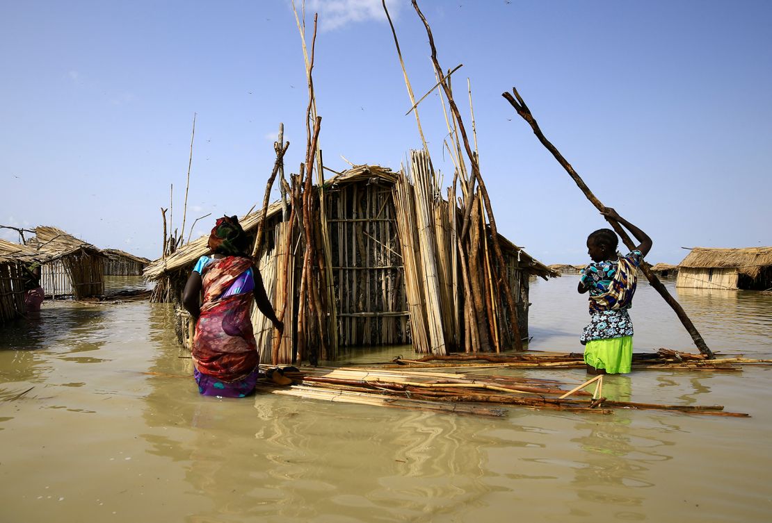 South Sudanese refugees try to repair their hut during the country's floods in 2021.