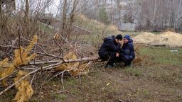 Vladimir is comforted by his wife Anna near a mass grave in the Kyiv suburb of Bucha.