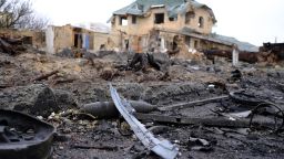 An unexploded ordnance remains on the ground in front of a destroyed house in the Kyiv suburb of Bucha.