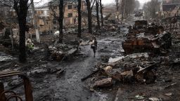 A woman walks amid destroyed Russian tanks in Bucha, in the outskirts of Kyiv, Ukraine, Sunday, April 3.