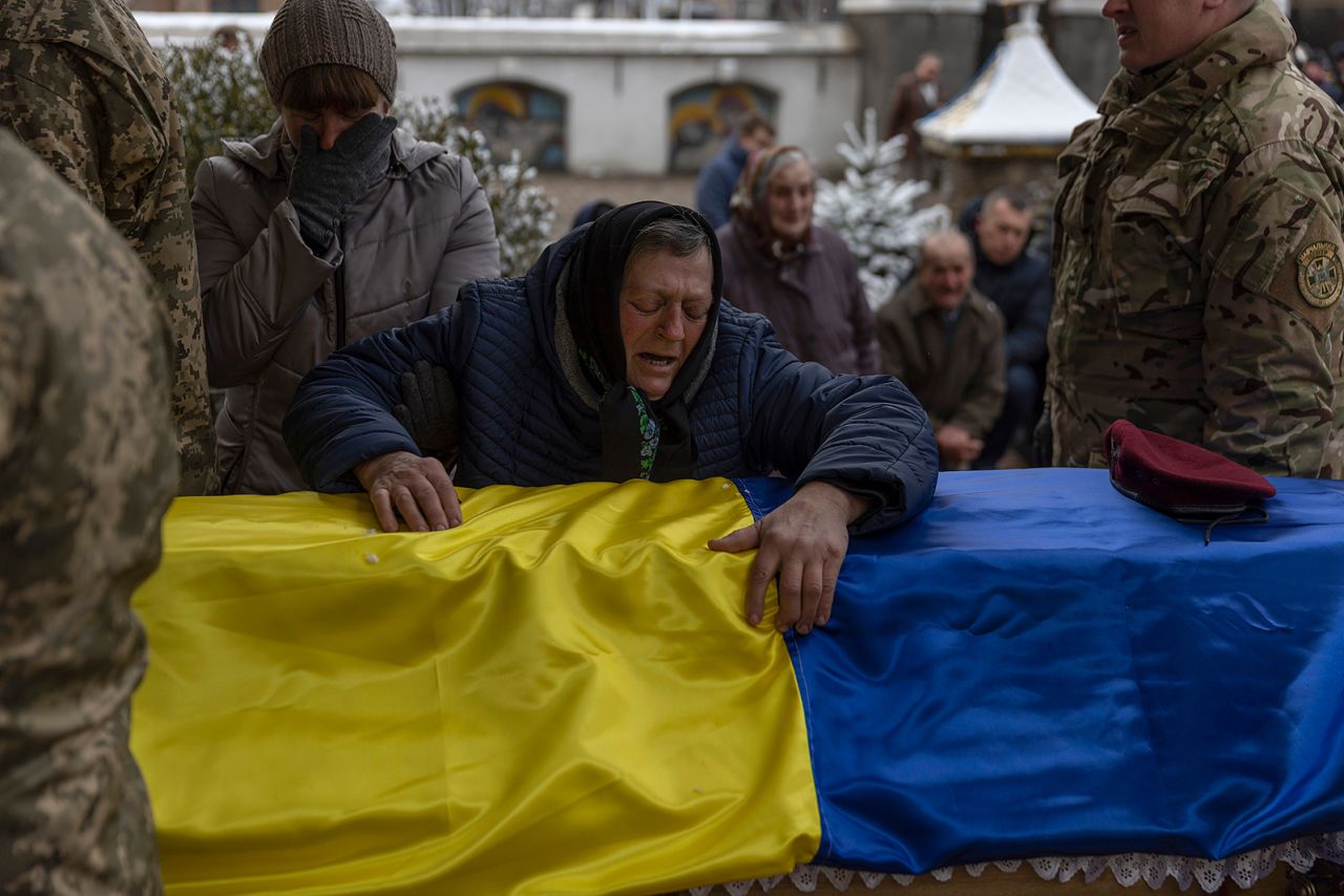 Anna Zhelisko touches the casket of her grandson, Ukrainian soldier Dmitry Zhelisko, as it arrives for his funeral in Chervonohrad, Ukraine, on April 3. He died fighting the Russian army near Kharkiv. 