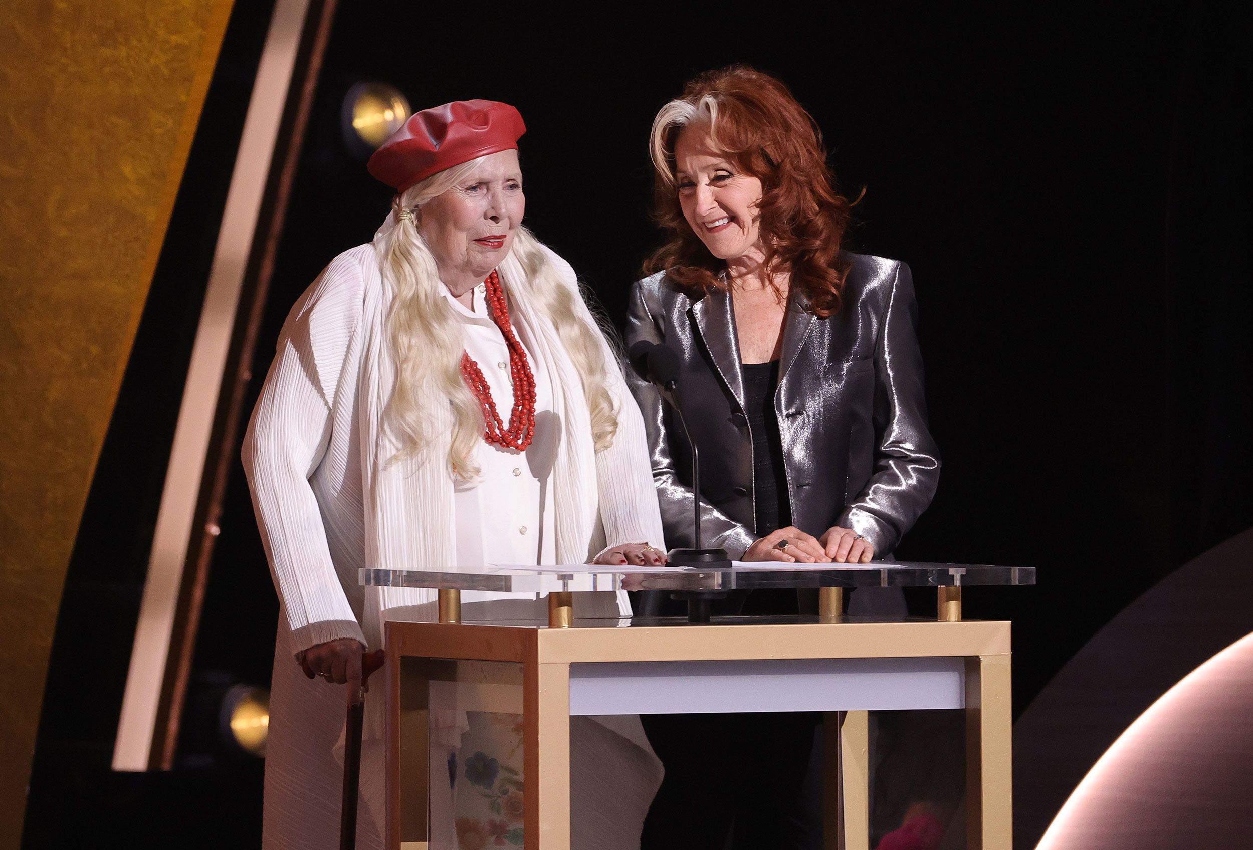 Joni Mitchell, left, and Bonnie Raitt speak on stage before introducing Brandi Carlile.