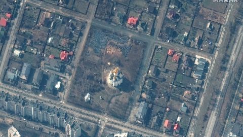 A satellite image from March 31 shows a grave site in Bucha, with an approximately 45-foot-long trench.