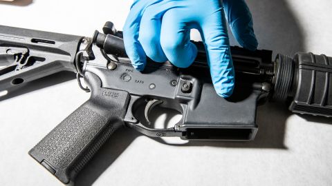 A police service technician with the Oakland Police Department Property and Evidence Unit points to a seized AR-15 assault rifle from a sample of ghost guns, or unregistered and untraceable firearms, at the department's headquarters in Oakland, California Thursday, April 15, 2021. 