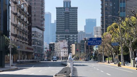 A worker in protective overall stands in the middle of empty streets in a lockdown area in the Jingan district of western Shanghai, Monday, April 4, 2022. 