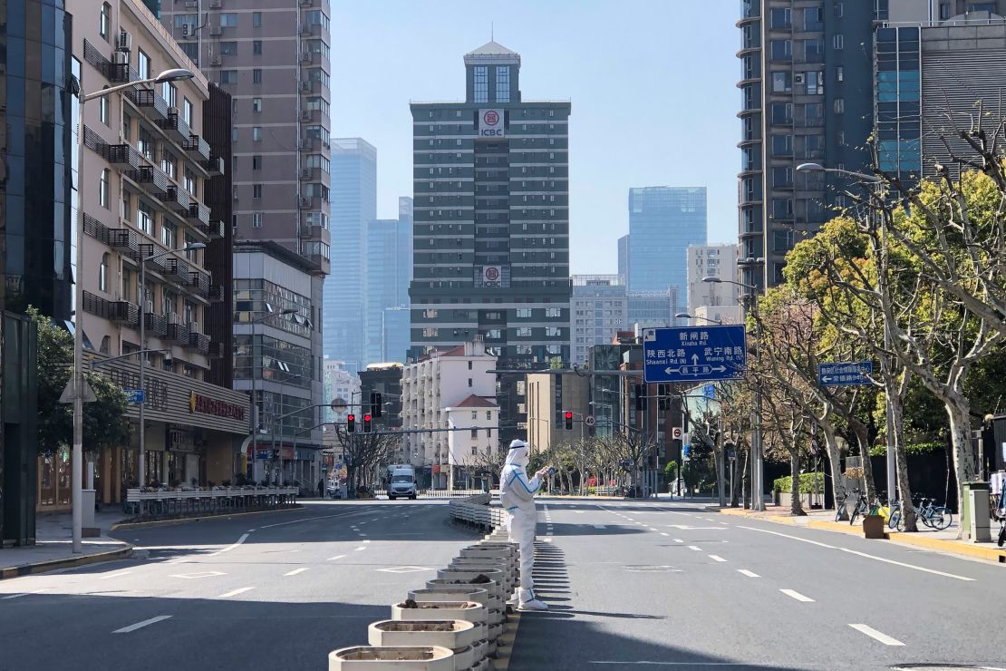 A worker stands in the middle of empty streets, in locked-down Shanghai on April 4.