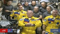 In this frame grab from video provided by Roscosmos, Russian cosmonauts Sergey Korsakov, Oleg Artemyev and Denis Matveyev are seen during a welcome ceremony after arriving at the International Space Station, Friday, March 18, 2022, the first new faces in space since the start of Russia's war in Ukraine. The crew emerged from the Soyuz capsule wearing yellow flight suits with blue stripes, the colors of the Ukrainian flag. (Roscosmos via AP)
