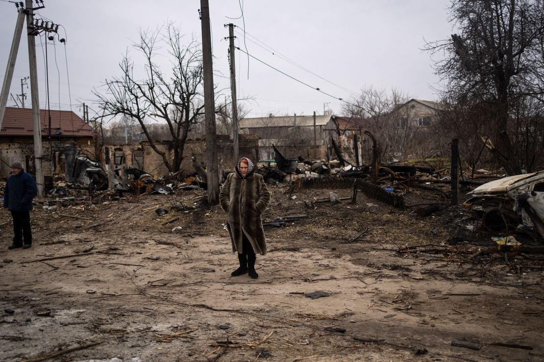 A woman stands in a destroyed area of Bucha on Tuesday.