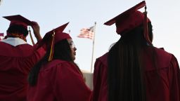 A US flag flies above a building as students earning degrees at Pasadena City College participate in the graduation ceremony, June 14, 2019, in Pasadena, California. - With 45 million borrowers owing $1.5 trillion, the student debt crisis in the United States has exploded in recent years and has become a key electoral issue in the run-up to the 2020 presidential elections.
"Somebody who graduates from a public university this year is expected to have over $35,000 in student loan debt on average," said Cody Hounanian, program director of Student Debt Crisis, a California NGO that assists students and is fighting for reforms. 