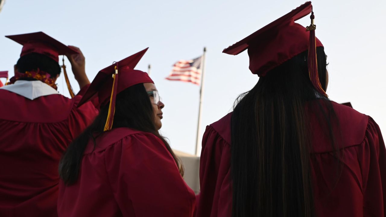 A US flag flies above a building as students earning degrees at Pasadena City College participate in the graduation ceremony on June 14, 2019.