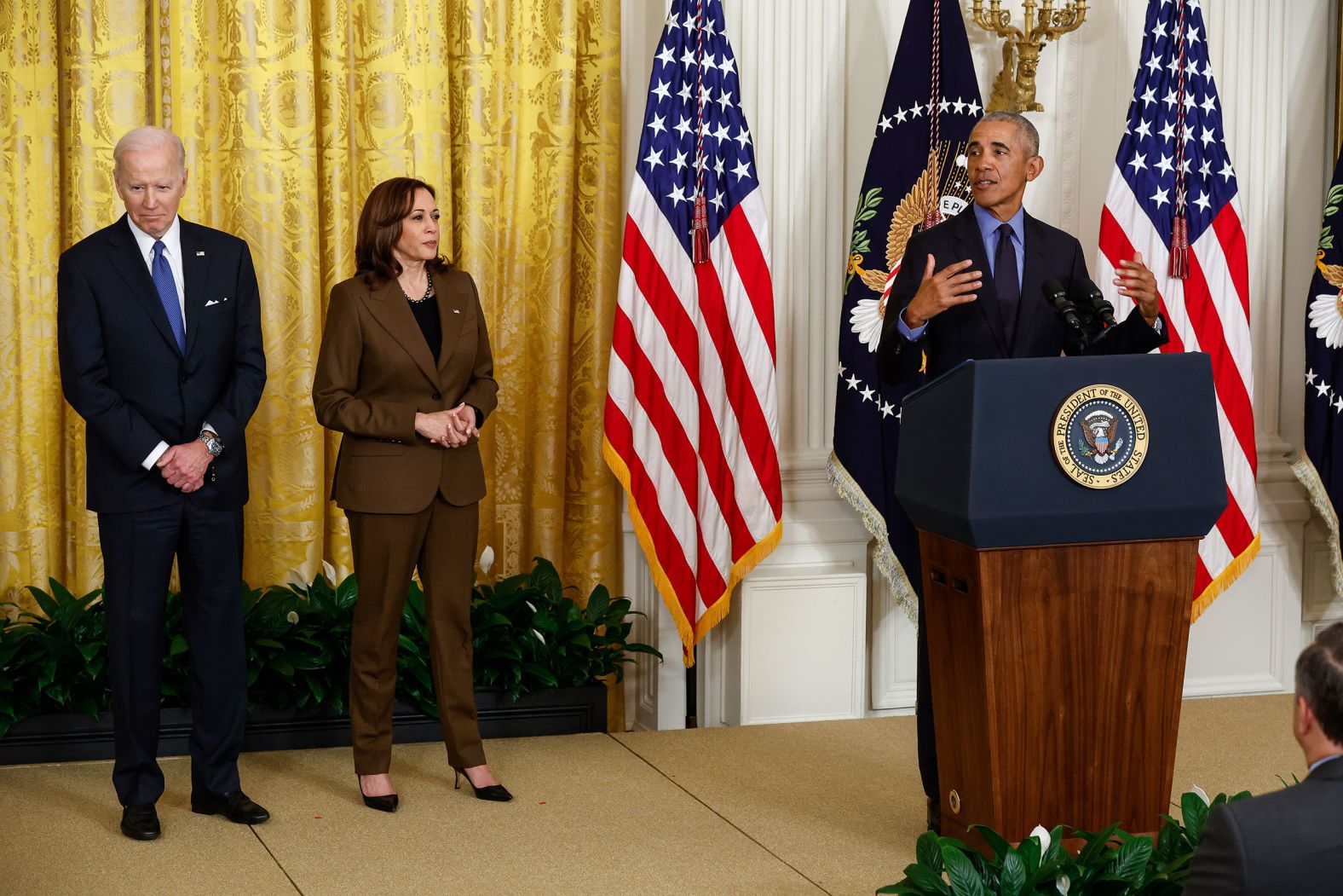 Obama delivers remarks from the East Room of the White House as Biden and Vice President Kamala Harris look on.