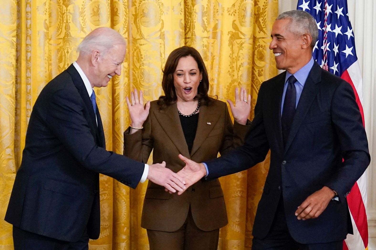 Harris reacts as Biden and Obama shake hands in the East Room.