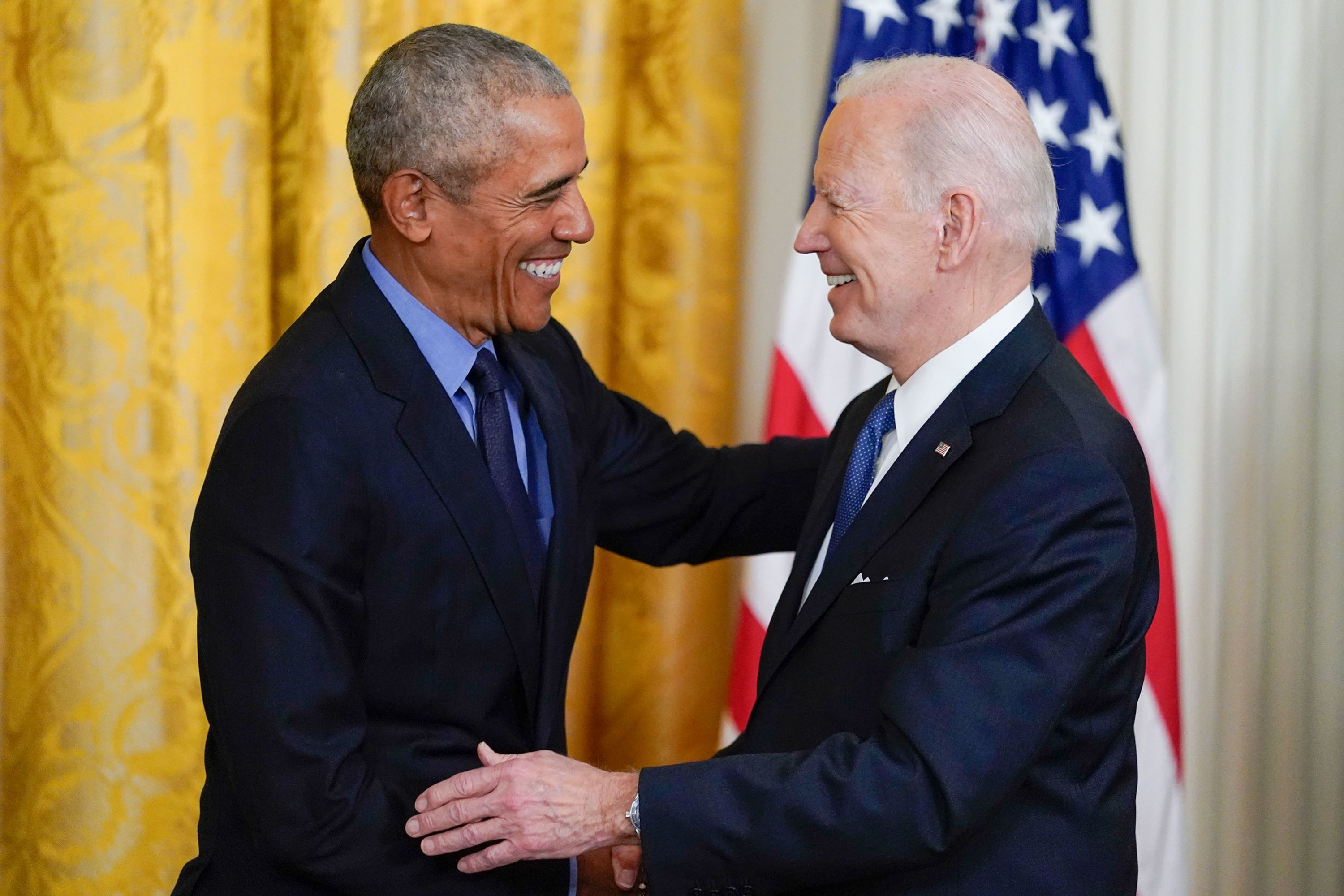 Former President Barack Obama shakes hands with President Joe Biden in the East Room of the White House on Tuesday, April 5
