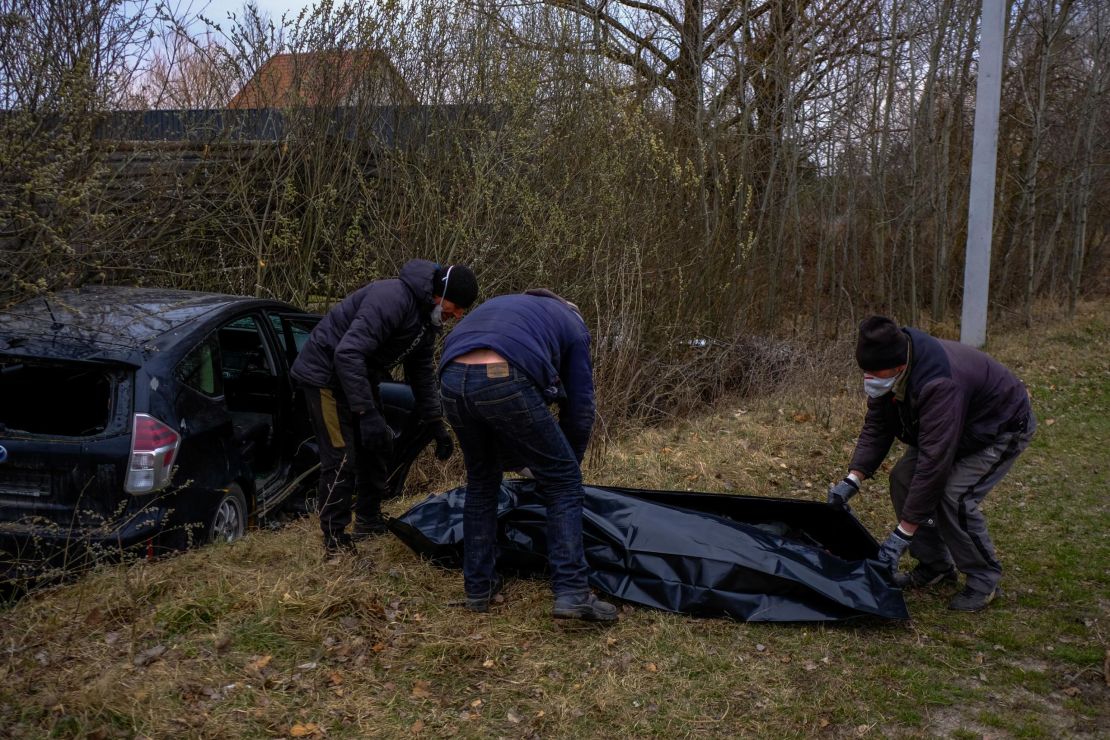 Volunteers collect the body of a man, shot dead in his car in Borodianka. They say he was transporting medical supplies.