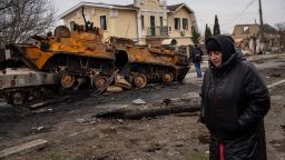 A woman walks next to a destroyed Russian armor vehicle in Bucha, in the outskirts of Kyiv, Ukraine, Tuesday, April 5, 2022. Ukraine's president plans to address the U.N.'s most powerful body after even more grisly evidence emerged of civilian massacres in areas that Russian forces recently left. 