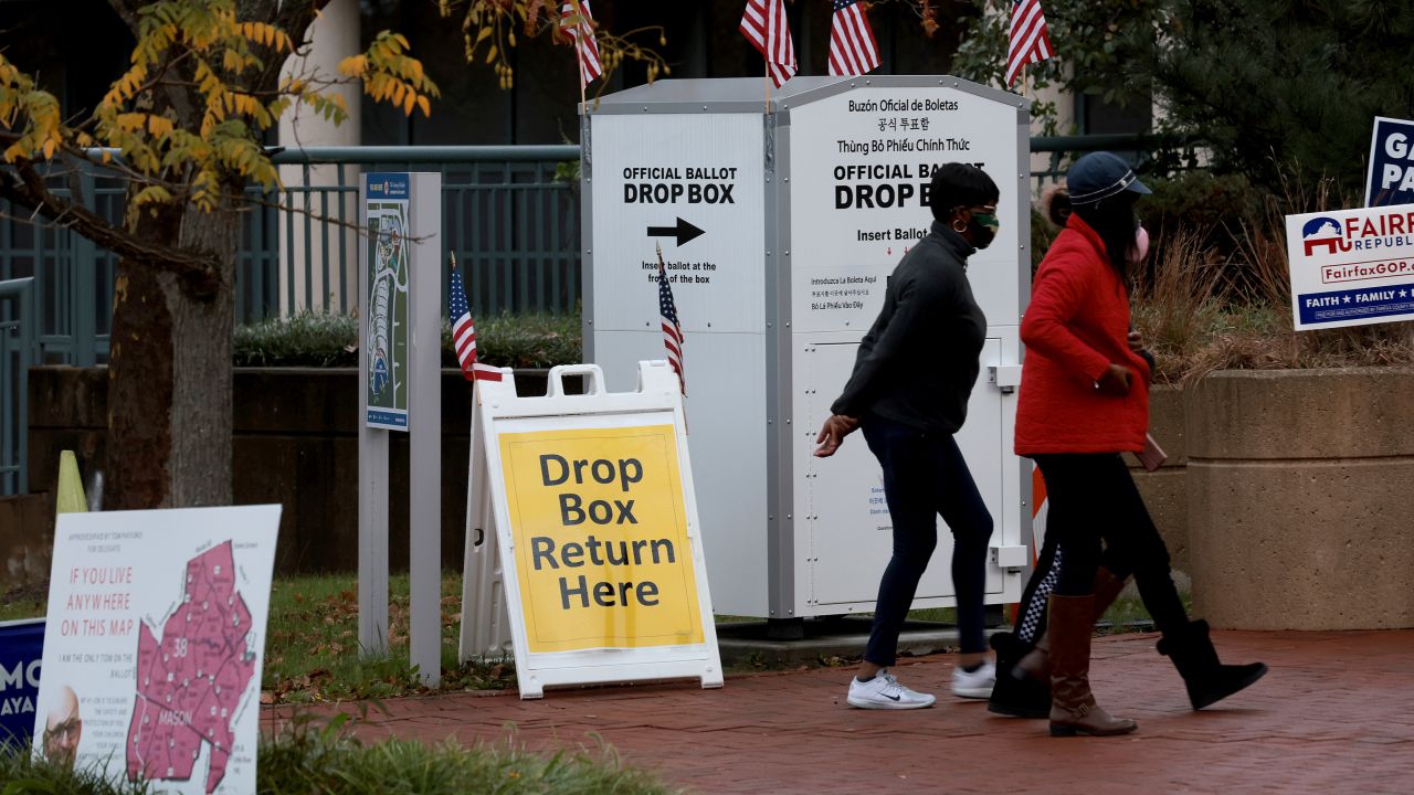 Voters walk past an official ballot drop box in front of the Fairfax County Government Center on November 2, 2021 in Fairfax, Virginia.