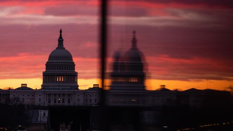 The US Capitol is reflected in an entrance to the Washington Monument at sunrise in Washington, DC, on Jan. 18, 2022. 