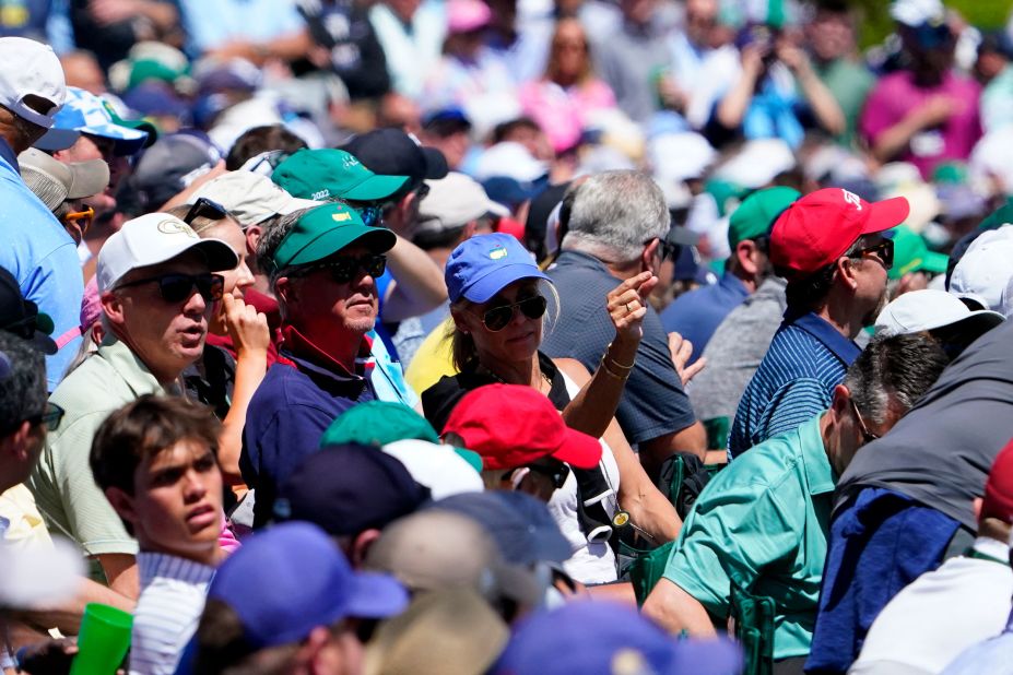 People watch Woods tee off on the 12th hole Thursday.