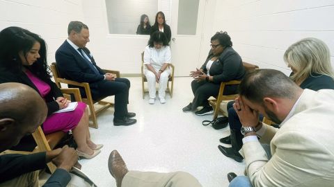 Texas death row inmate Melissa Lucio, dressed in white, prays April 6 with Texas lawmakers at the Mountain View Unit in Gatesville, Texas.