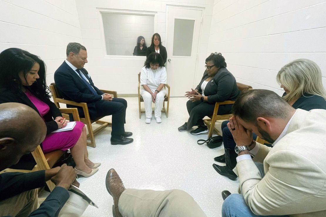Texas death row inmate Melissa Lucio, dressed in white, prays April 6 with Texas lawmakers at the Mountain View Unit in Gatesville, Texas.