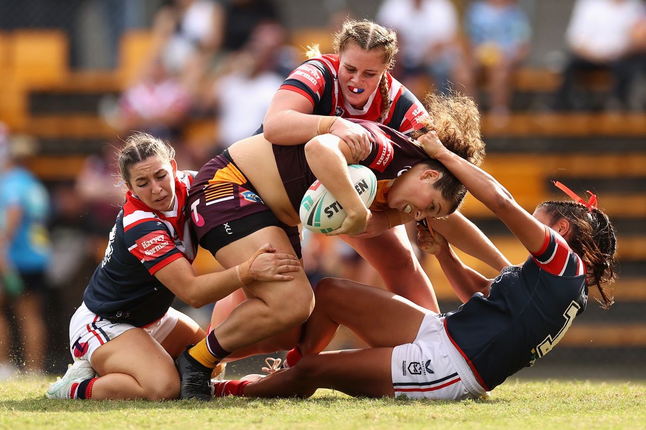 Chelsea Lenarduzzi, a rugby player with the Brisbane Broncos, is tackled by several Sydney Roosters during a match in Sydney on Sunday, April 3.