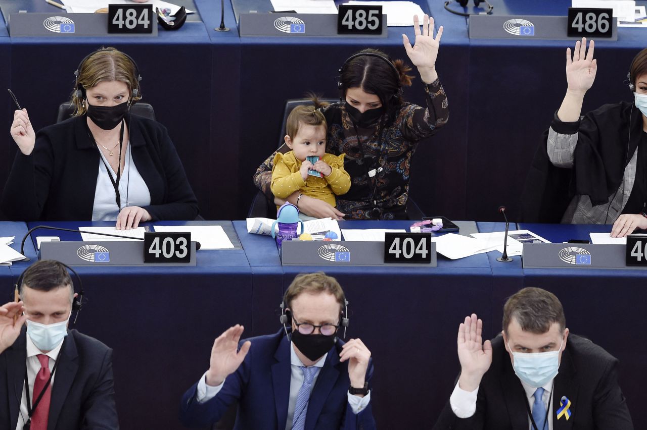 Irena Joveva, a member of the European Parliament, holds her daughter as she takes part in a vote in Strasbourg, France, on Tuesday, April 5.