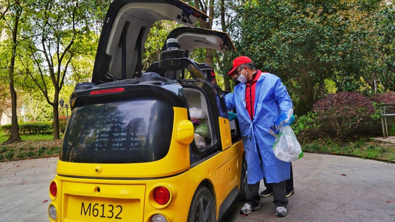 A worker sorting goods stored in a Meituan delivery vehicle.