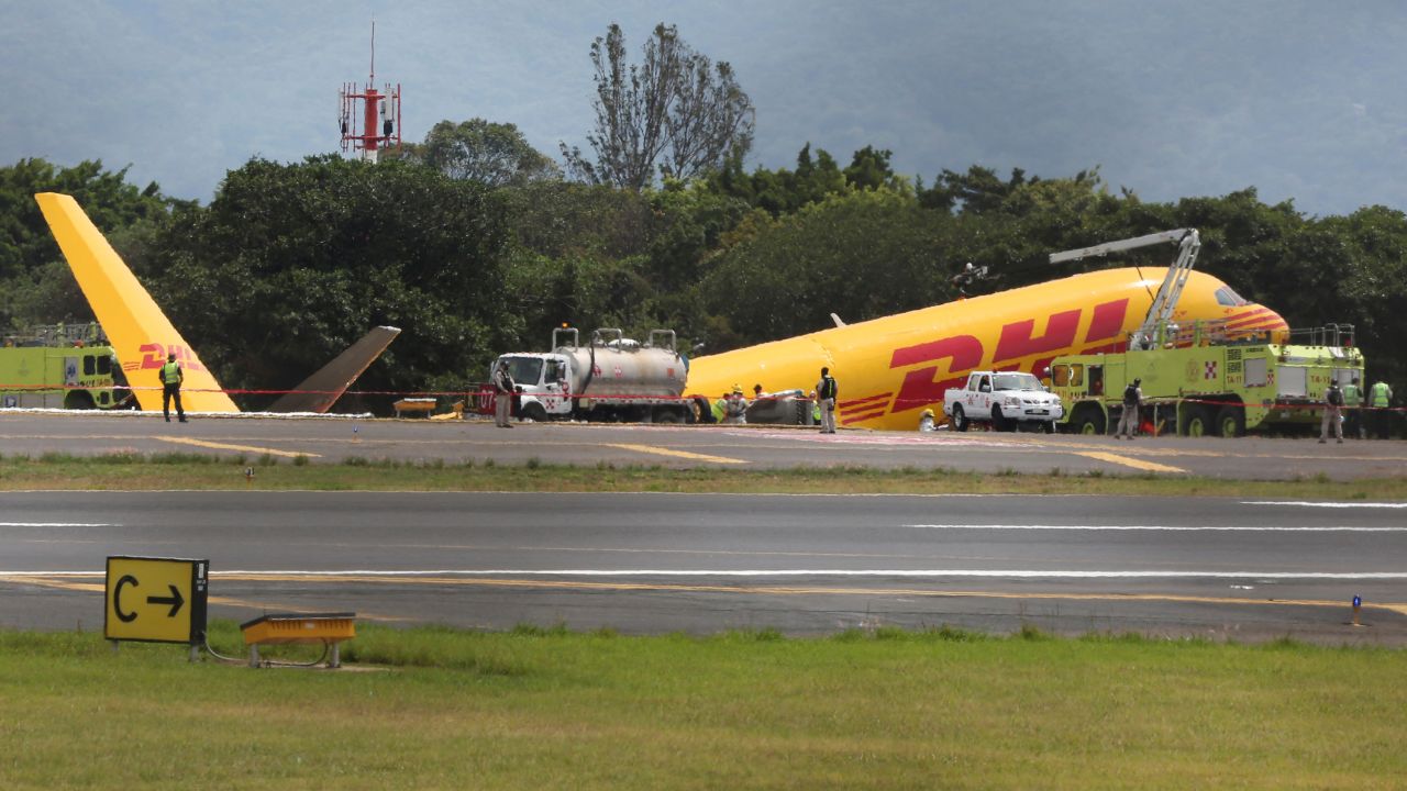 Firefighters work at the scene where a Boeing 757-200 cargo aircraft operated by DHL made an emergency landing before skidding off the runway and splitting, aviation authorities said, at the Juan Santamaria International Airport in Alajuela, Costa Rica April 7, 2022.