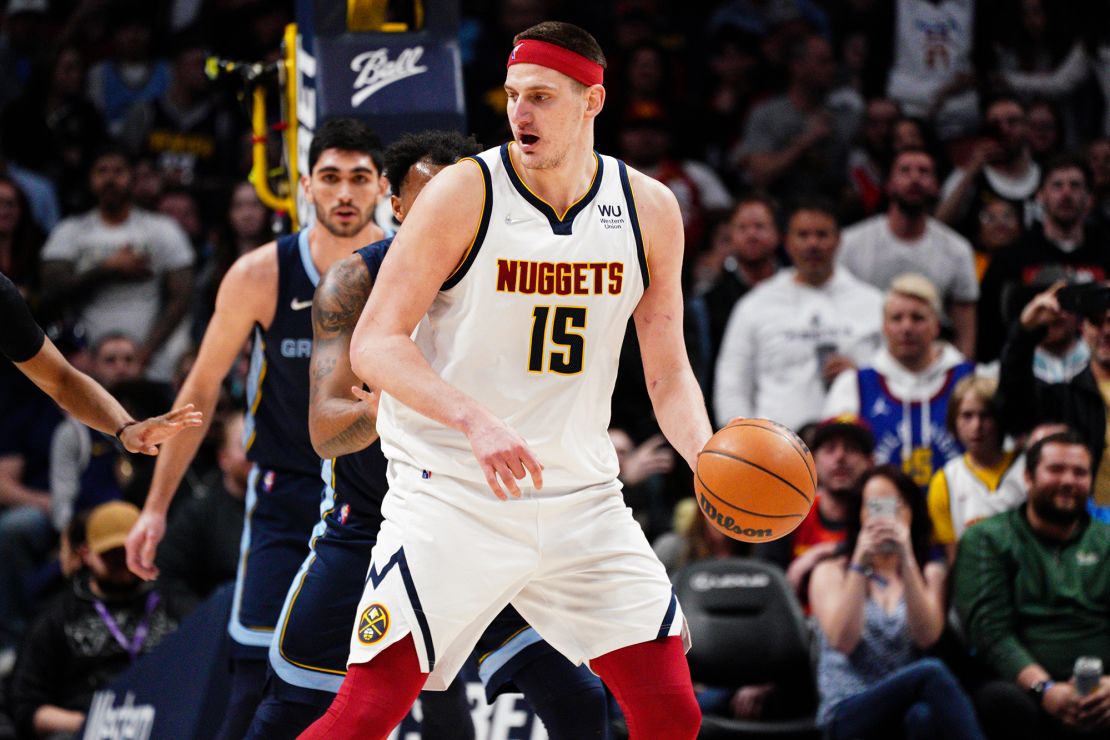 Jokic, sporting a red headband, posts up defenders.