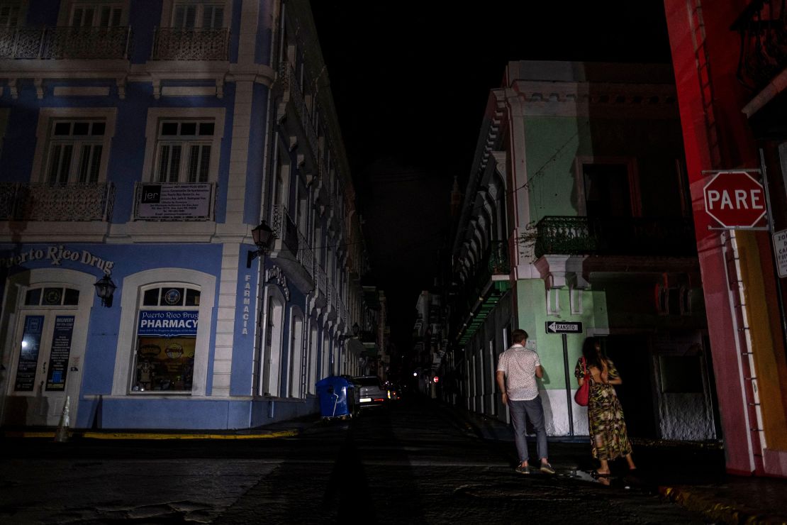 A couple walks on a dark street in San Juan after the April 6 blackout.