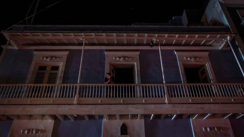 A man stands on a balcony in San Juan after a major power outage hit Puerto Rico Wednesday evening.