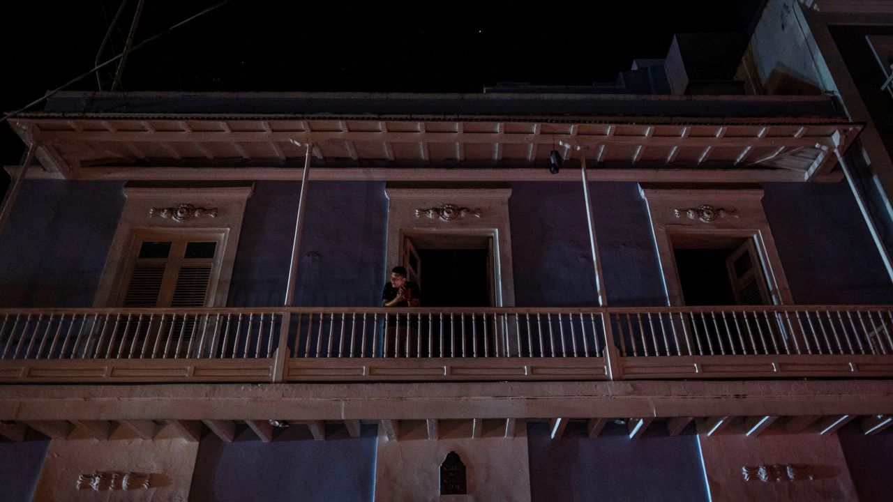 A man stands on a balcony in San Juan after a major power outage on April 6, 2022.