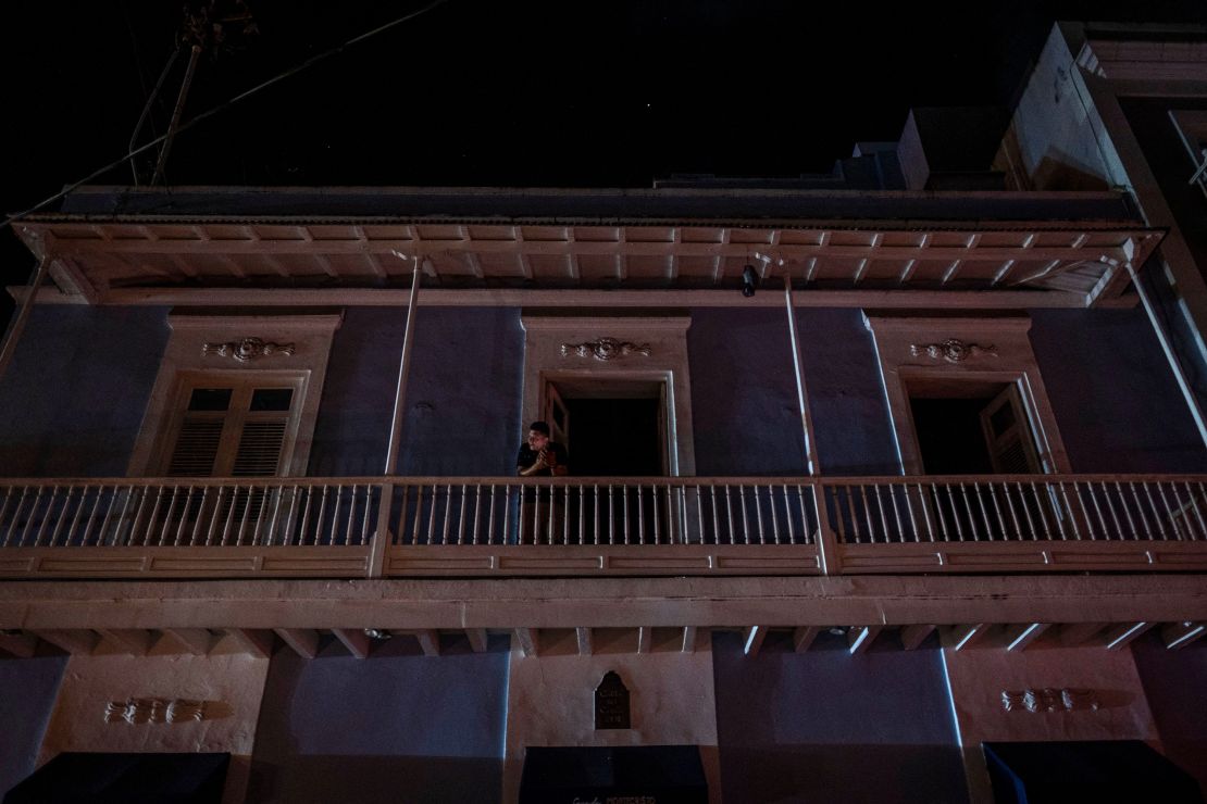 A man stands on a balcony in San Juan after a major power outage hit Puerto Rico Wednesday evening.