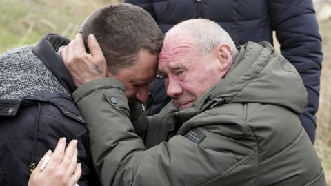 Relatives cry at the mass grave of civilians killed during the Russian occupation in Bucha, on the outskirts of Kyiv, Ukraine, Friday, April 8, 2022. 